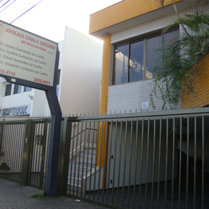 No canteiro da parte superior do sobrado, as plantas se debruçam sobre a frente azulejada do escritório de Uberlândia/MG.