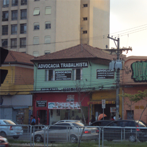 Das janelas do escritório localizado em sobrado de construção antiga, vê-se o movimentado trânsito da capital paulista, São Paulo.