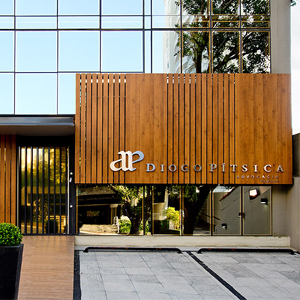 Os painéis de madeira na vertical realça o desenho reto e moderno da fachada contemporânea do escritório de Florianópolis/SC. 