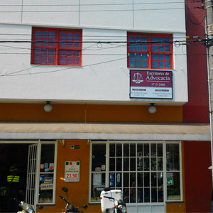 As janelas vermelhas do escritório de Poços de Caldas/MG se destacam na fachada branca. 