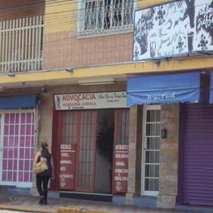 As áreas de atuação do escritório de São Sebastião do Paraíso/MG aparecem dispostas nas laterais da porta de vidro e ferro. 