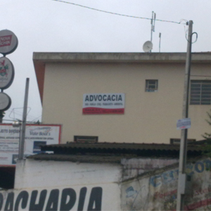 Na lateral do prédio nota-se a placa bicolor indicando a presença de um escritório na Cidade das Águas, Igaratá/SP. 