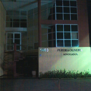 Na escuridão da noite de Ribeirão Preto/SP, o nome do escritório é realçado pela luz verde que sai do canteiro. 