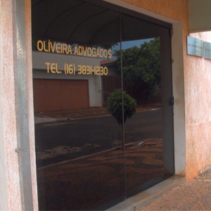 Da porta de vidro do escritório nota-se a pacata rua de Guará/SP.