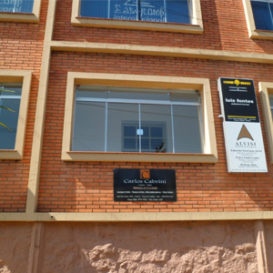 A placa do escritório de Poços de Caldas/MG sobressai na fachada do prédio de tijolos à vista. 
