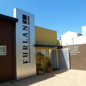 A placa metalizada com o nome do escritório de Marília/SP se destaca entre as paredes coloridas.
