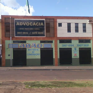 A grande placa indica a presença da banca advocatícia em Serrana/SP, que honra a pátria com a bandeira do Brasil no telhado.